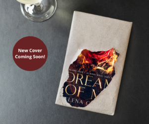 Partially hidden book cover of the new edition of Dream of Me by Selena Collins sitting on a grey table with a glass of wine